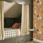 Built-in bunk bed with striped privacy curtains, olive green paneling, and whimsical dragon wallpaper in a cozy, attic-style bedroom.