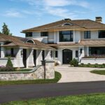 Stately coastal-style residence with cedar shingles, arched dormers, and manicured landscaping framed by a curved stone entry wall.