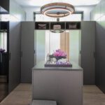 Modern walk-in closet with sleek cabinetry, a central island, and stylish lighting fixture, designed by LDa Architecture.