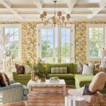 Green sectional and patterned accents in floral-filled living room