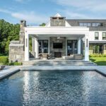 Modern backyard with rectangular pool, stone patio, and covered outdoor living space in Connecticut
