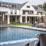 Rear view of luxury Connecticut home with pool and cascading water feature