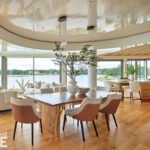 Elegant open-concept dining room with water views and curved ceiling