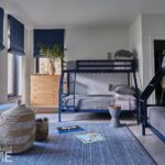Stylish modern bunk room with navy blue beds and matching Roman shades