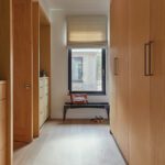 Light-filled hallway with custom wood cabinetry and bench