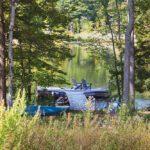 Tranquil dock with Adirondack chairs overlooking a wooded lake
