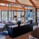 Open-concept great room with wood beams and modern shelving