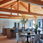 Vaulted kitchen and dining area with wood beams and modern furnishings