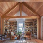 Home library with wood-paneled ceiling and built-in bookshelves