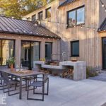 Modern patio with built‑in concrete grill station and string‑light canopy