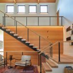Open tread staircase with cable railing and wood accent wall