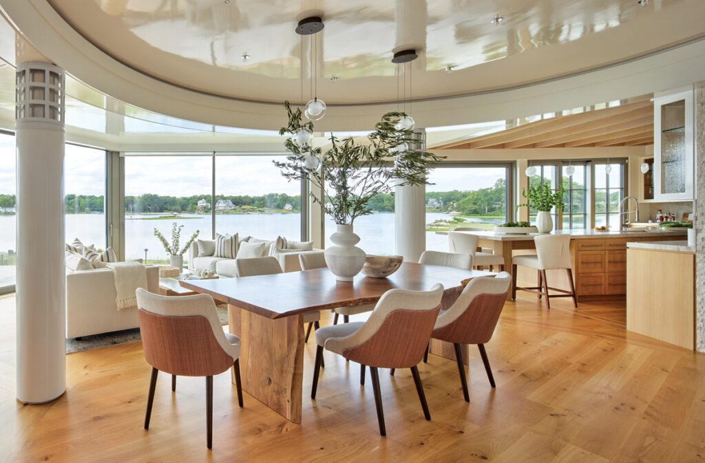 Elegant open-concept dining room with water views and curved ceiling