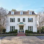 Stately white historic home with symmetrical façade and manicured landscaping.
