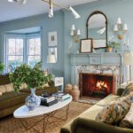 Elegant living room with blue walls, marble fireplace, and midcentury chandelier by Erin Gates.
