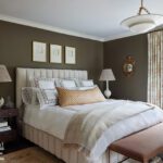 Sophisticated primary bedroom with tufted headboard, dark brown walls, and patterned lampshades by Erin Gates.