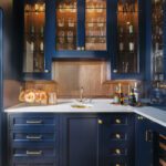 Elegant navy butler’s pantry with glass-front cabinets, brass hardware, and marble countertop