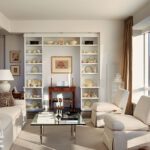 Chic living room with white upholstery, built-in shelving, and panoramic city views in a Boston high-rise.