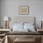 Serene primary bedroom with upholstered headboard, symmetrical nightstands, and minimalist artwork.