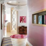 Hallway with curved pink accent wall, crystal lighting, and bold artwork.