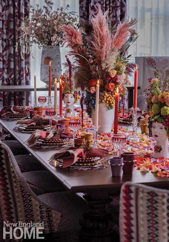 An opulently set table with pampas grasses, rose petals, and bold color. 