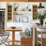 Kitchen banquette with built-in seating, wood table, and open shelving.