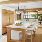 Kitchen island with marble waterfall countertop and wood framing.