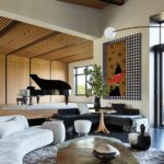 Elevated music room with grand piano, curved sectional seating, and midcentury-inspired decor.
