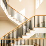 Bright contemporary staircase with black railings, wood accents, and floating design in a light-filled atrium.