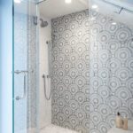 Modern glass shower with patterned gray and white tile