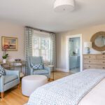 Cozy guest suite with blue armchairs and ensuite bathroom
