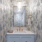 Elegant powder room with blue patterned wallpaper and brass accents
