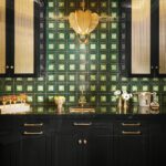 Black cabinetry pantry with green tiled backsplash and gold pendant light