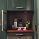 Built-in coffee station with wood counter and green cabinetry.