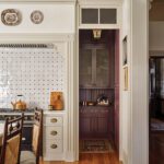 Elegant kitchen range with tiled backsplash, cream cabinets, and brass accents.