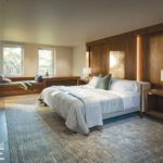 Contemporary bedroom with wood accent wall and window seat