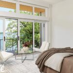 Bright bedroom with glass doors to balcony overlooking the lake.