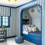 Blue-and-white striped sleeping nook with built-in bed and playful lighting.
