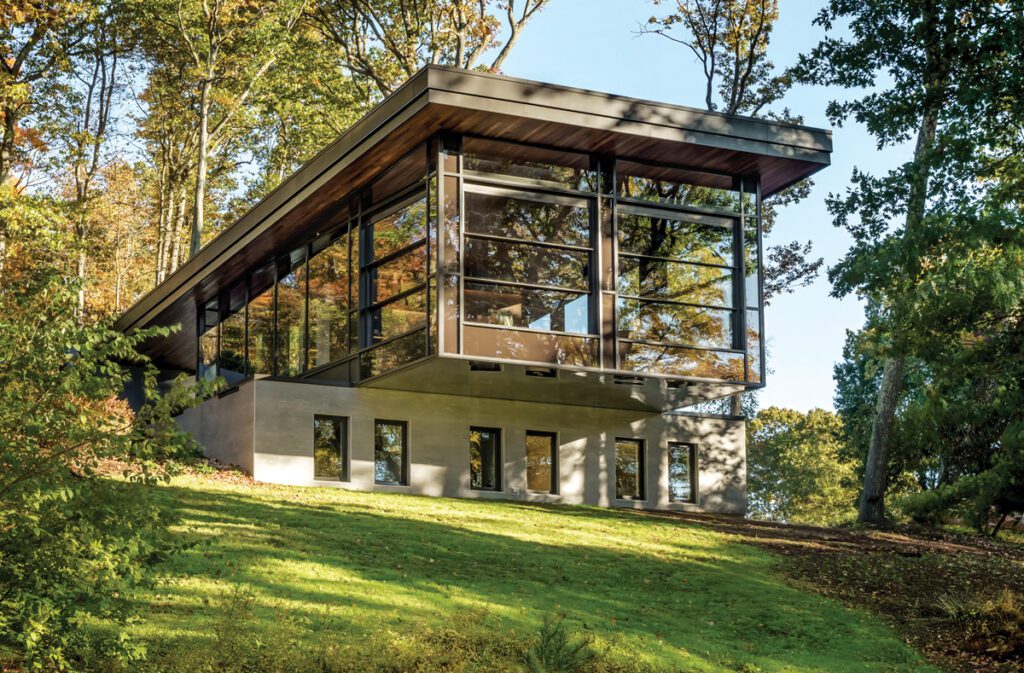 Modern glass-walled home on a wooded hillside in Connecticut