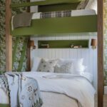 A playful bunk room with bold green built-in beds, white shiplap walls, and patterned wallpaper, blending rustic charm with modern comfort.
