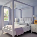 Lavender bedroom with upholstered four-poster bed, tufted headboard, and layered linens in a Boston townhouse.