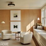 Family room with woven wallcovering, modern artwork, swivel chairs, and built-in window seat.