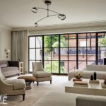 Neutral living room with modern seating, floor-to-ceiling windows, and garden views.
