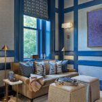 Light-filled study with sofa, ottomans, and framed bird prints.