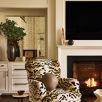 Cozy fireplace vignette with patterned chair and white millwork