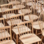 Collection of unfinished handcrafted wooden chairs in workshop