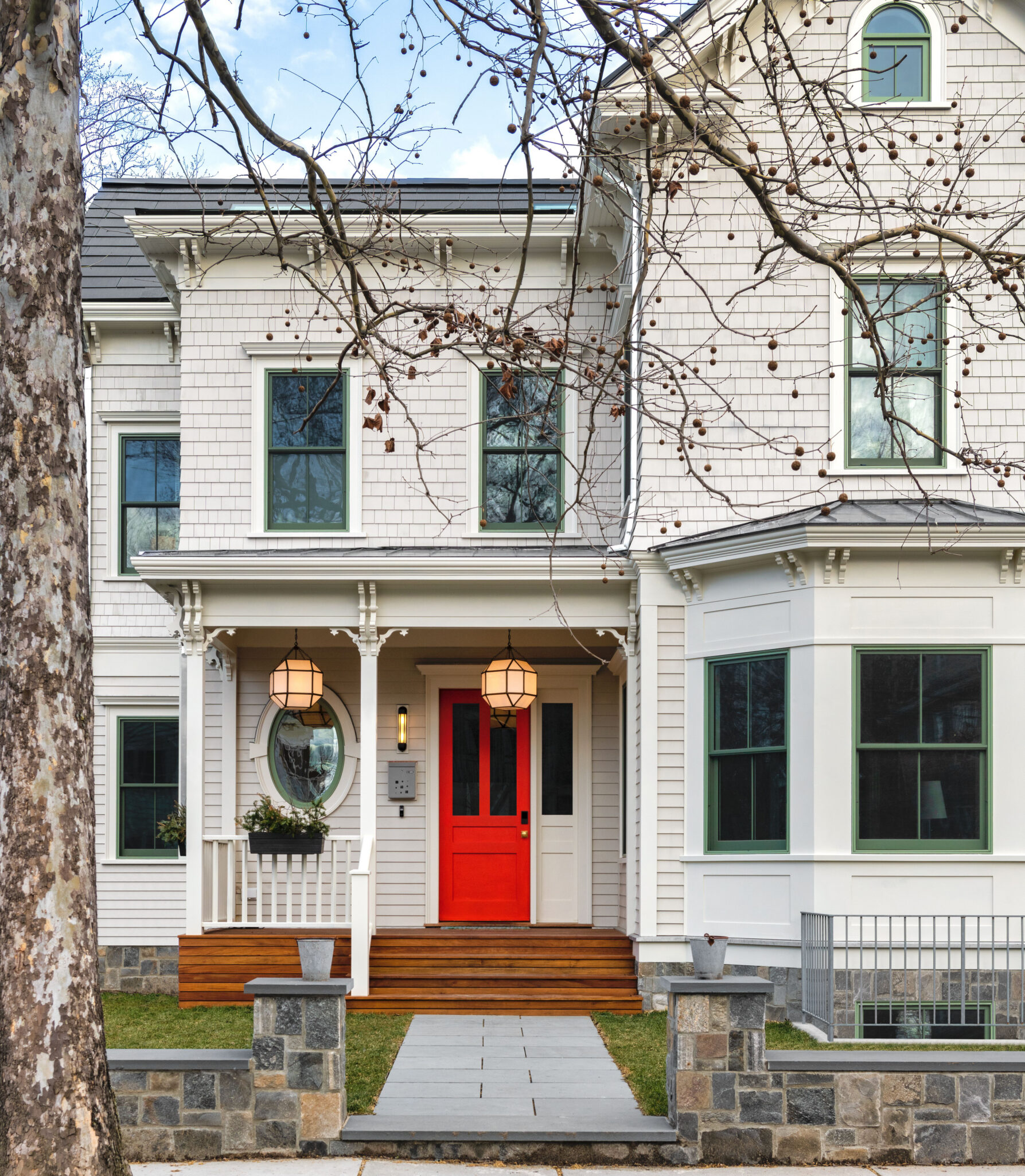 Historic New England home with white shingle siding and green double-hung replacement windows.