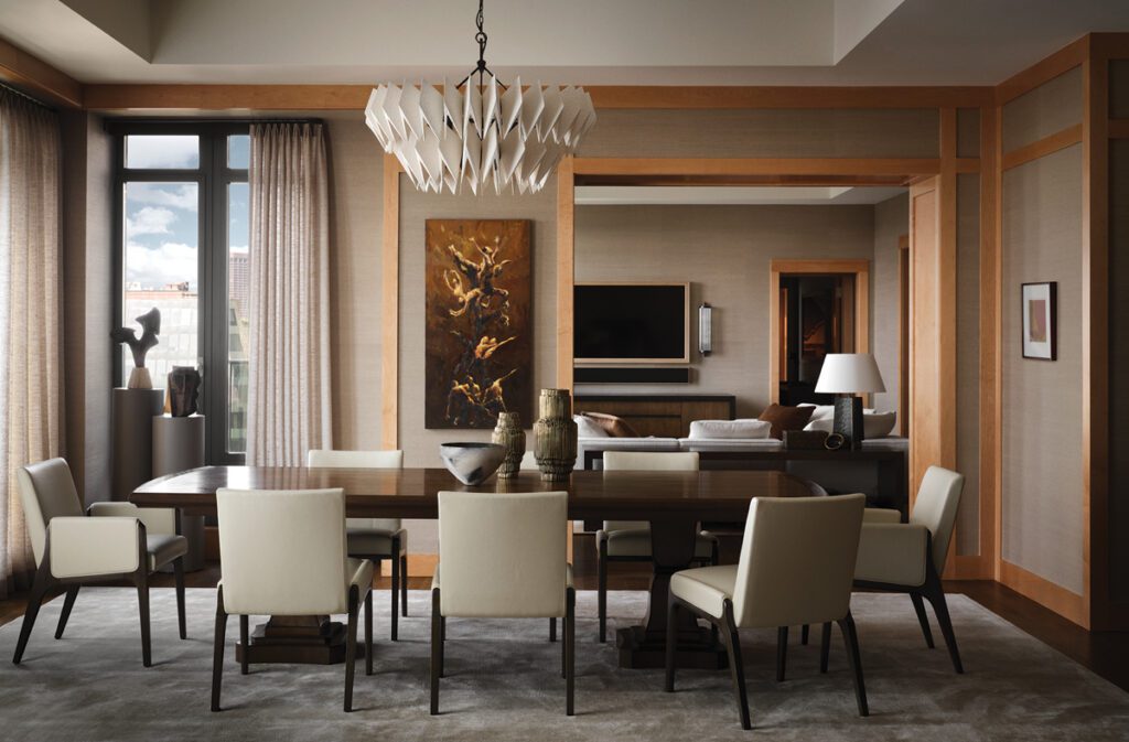 Contemporary dining room with wood paneling, sculptural chandelier, and upholstered chairs.