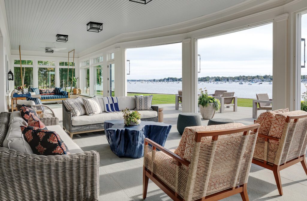 Screened porch with woven furnishings and panoramic harbor views.