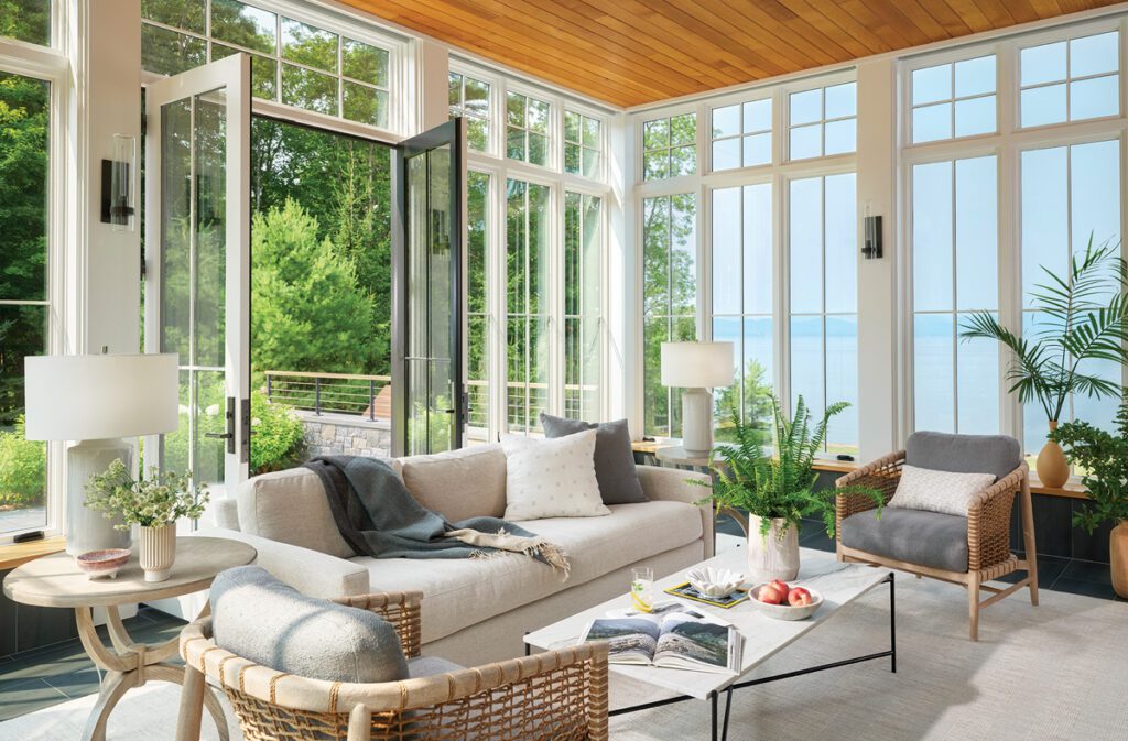 Screened porch with wood ceiling, lake views, and woven seating.